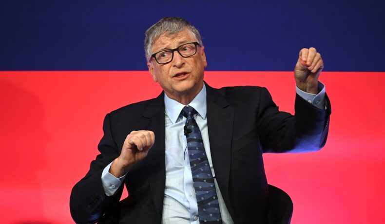 Bill Gates, pe scena evenimentului Global Investment Summit, 2021, organizat în Londra, Marea Britanie. Gates poartă un costum închis la culoare, cămașă albă, cravată. Pe fundal cu roșu și albastru. Bill Gates a dezvăluit ce crede despre Metavers