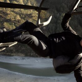 Tom Cruise, în filmul Mission Impossible, îmbrăcat în negru, în timp ce stă atârnat de un elicopter. Tom Cruise va filma în spațiu după următorul film din serie