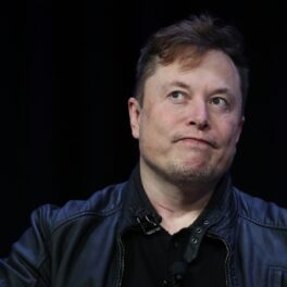 Elon Musk, pe scenă la Satellite Conference and Exhibition, martie 2020. Poartă un costum negru și e pe un fundal negru. Acum, Elon Musk susține că a plătit taxe record