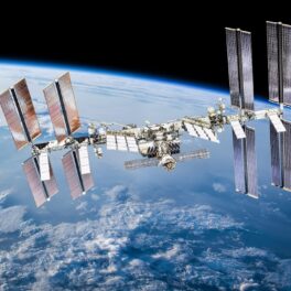 Stația Spațială Internațională, pe care vrea să o distrugă NASA, în orbita Pământului, cu planeta pe fundal și negru în conțul dreapta sus
