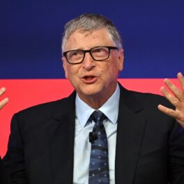 Bill Gates, pe scena Global Investment Summit, 2021, Science Museum. Poartă un costum negru, cămașă albă, cu albastru și roșu pe fundal. Vila „de burlac” a lui Bill Gates deranjează vecinii