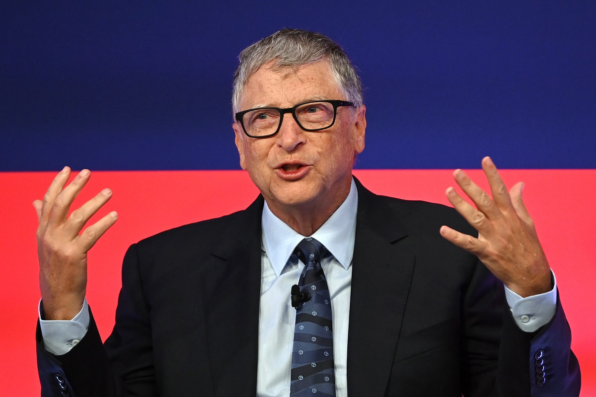 Bill Gates, pe scena Global Investment Summit, 2021, Science Museum. Poartă un costum negru, cămașă albă, cu albastru și roșu pe fundal. Vila „de burlac” a lui Bill Gates deranjează vecinii