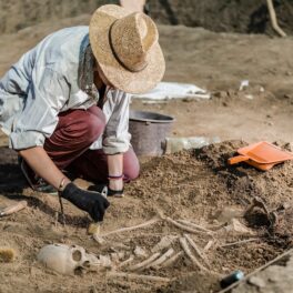 Arheolog care examinează un schelet în mormânt. Experții au dezvăluit cum arăta un „vampir” din secolul 18