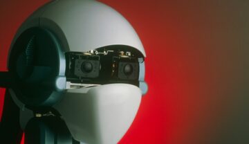 Capul unui robot umanoid, pe fundal roșu. Robotul umanoid care își schimbă forma a fost dezvăluit recent