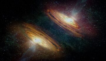 Două galaxii, în nuanțe de portocaliu, pe fundal negru. Galaxia canibală care își „devorează” vecinii a fost descoperită recent