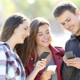 3 tineri care folosesc telefoane mobile, pentru a ilustra ce părere are martin cooper, „părintele mobilului”, despre dispozitiv