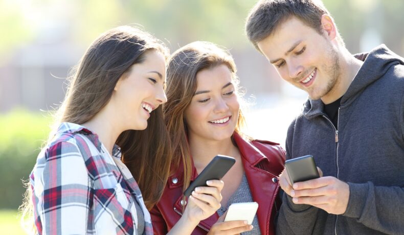 3 tineri care folosesc telefoane mobile, pentru a ilustra ce părere are martin cooper, „părintele mobilului”, despre dispozitiv