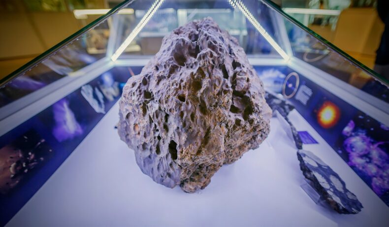 Meteoritul Chelyabinsk, care a căzut pep Pământ în 2013, expus pe o masă albă, pentru a ilustra primul „meteorit bumerang” al Pământului