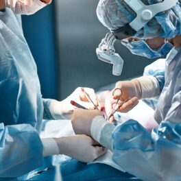 Operație chirurgicală, cu doctori care fac operația, îmbrăcați în albastru, pentru a ilustra cum un organ „inutil” din corp e important
