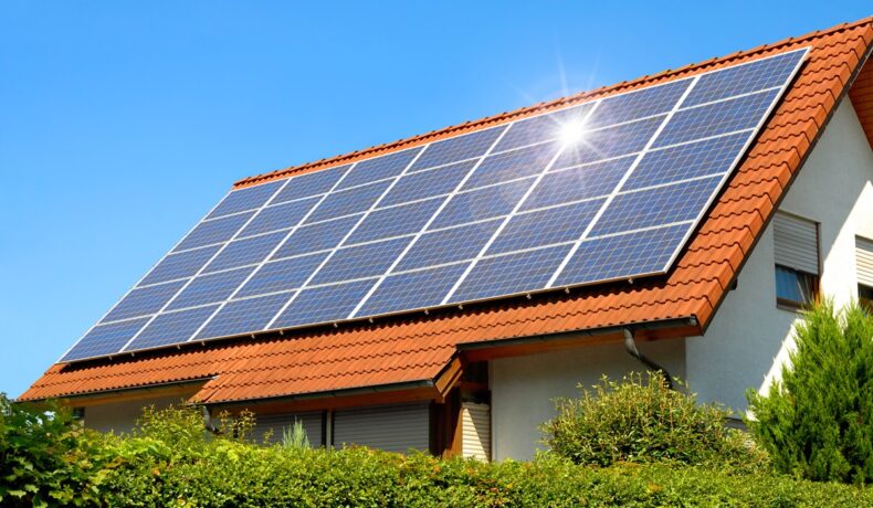 Panouri solare, precum cele create dintr-un „material miraculos”, pe o casă cu acoperiș roșu