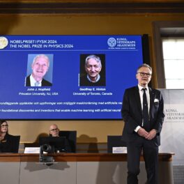 Scenă de la decernarea Premiului Nobel pentru Fizică în 2024, 8 octombrie. Pe un ecran albastru apar John Hopfield şi Geoffrey Hinton